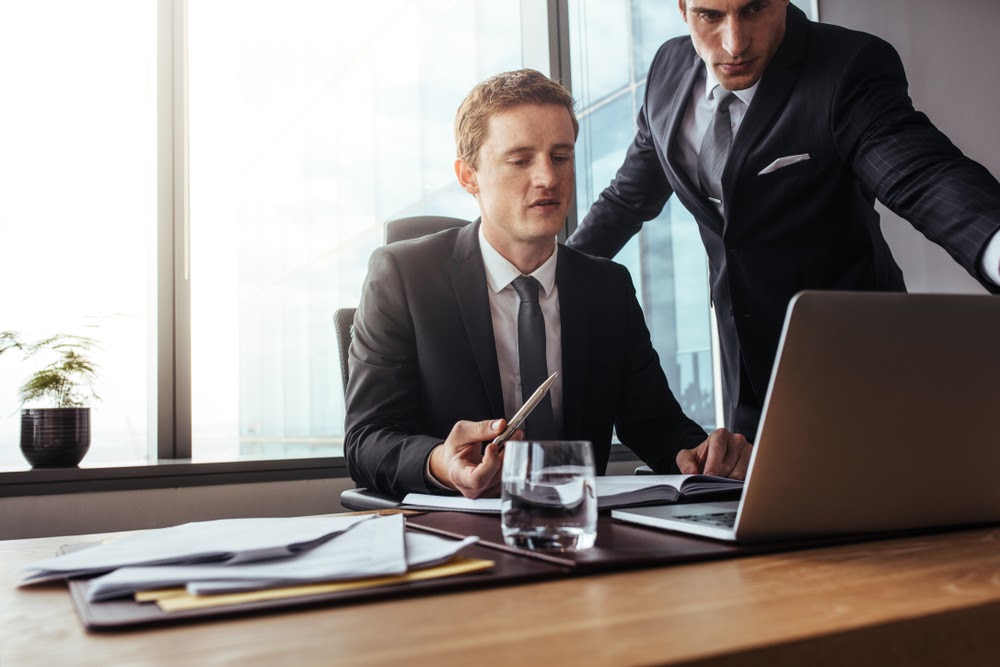 lawyers discussing law firm efficiency in front of a computer